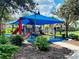 Community playground shaded by a large awning with multiple slides and climbing areas for children to enjoy outdoors at 4002 Sunset Lake Dr, Lakeland, FL 33810