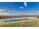 Scenic view of a tranquil pond reflecting the blue sky, surrounded by lush green grass at 4002 Sunset Lake Dr, Lakeland, FL 33810