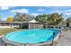 A wide view of the large grassy back yard featuring an above-ground pool and a screened porch at 4035 Crews Ln, Lakeland, FL 33813