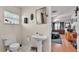 Bathroom with a pedestal sink, toilet, window, and a view into the bedroom, featuring hardwood floors and nice decor at 4035 Crews Ln, Lakeland, FL 33813