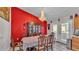 Dining room with large chandelier and bright red accent wall at 4035 Crews Ln, Lakeland, FL 33813