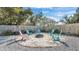 Outdoor fire pit area featuring light colored sand, a brick border, and colorful chairs, perfect for entertaining at 4035 Crews Ln, Lakeland, FL 33813