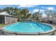 A blue above-ground pool surrounded by green lawn, chairs and tasteful landscaping at 4035 Crews Ln, Lakeland, FL 33813