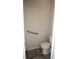 Small bathroom with a toilet, grab bar for assistance, and tile flooring with a door to exit at 4080 Prima Lago Cir, Lakeland, FL 33810