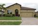 Charming single-story home features a tile roof, tan stucco exterior, and well-maintained front lawn at 4080 Prima Lago Cir, Lakeland, FL 33810