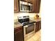 Close-up of kitchen with stainless steel range, microwave, dark cabinets, and granite countertops at 4080 Prima Lago Cir, Lakeland, FL 33810