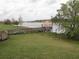 Beautiful lake view featuring a gazebo at the end of a dock, surrounded by green grass and mature trees at 4080 Prima Lago Cir, Lakeland, FL 33810