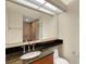 Bathroom featuring a dark granite countertop, mirror, and glass-enclosed shower at 417 Enclave Pl # 2, Lakeland, FL 33803