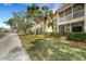 Charming exterior view of a residential building featuring palm trees, well-maintained landscaping, and screened patios at 417 Enclave Pl # 2, Lakeland, FL 33803