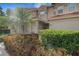 Two story tan home featuring a palm tree and manicured bushes at 417 Enclave Pl # 2, Lakeland, FL 33803