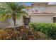 Two story tan home featuring a palm tree and manicured bushes at 417 Enclave Pl # 2, Lakeland, FL 33803