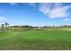 View of community golf course with mature palm trees and a water fountain at 417 Enclave Pl # 2, Lakeland, FL 33803