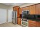 This kitchen features stainless steel appliances and stylish wood cabinetry with black countertops at 417 Enclave Pl # 2, Lakeland, FL 33803