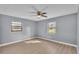 This bedroom features modern wood-look floors, two windows and a ceiling fan at 4601 Sw Reynosa Sw Dr, Winter Haven, FL 33880