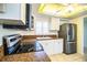 Kitchen with stainless steel appliances, white cabinetry, granite countertops and plantation shutters at 474 Cameo Dr, Lakeland, FL 33803