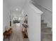 Bright hallway featuring wood-look tile floors and a staircase leading to the upper level at 5002 Rain Shadow Dr, St Cloud, FL 34772