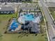 Aerial view of a community pool, covered playground, and well-manicured landscaping at 5002 Rain Shadow Dr, St Cloud, FL 34772