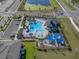 Aerial view of community pool, playground, and parking area near a pond at 5002 Rain Shadow Dr, St Cloud, FL 34772