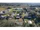 An aerial view showcases the home and neighboring properties within a serene, wooded community at 5121 Idlewood Ln, Lakeland, FL 33811