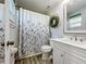 Bright bathroom featuring updated fixtures, framed mirror, white vanity and a tub-shower combination at 5121 Idlewood Ln, Lakeland, FL 33811