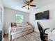 Bright bedroom with a trundle bed, ceiling fan, mounted TV and dark wood-look floors at 5121 Idlewood Ln, Lakeland, FL 33811