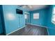 Light blue bedroom with grey laminate flooring, a ceiling fan, and a mirrored closet at 526 Hampton Ave, Lakeland, FL 33801