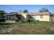 Rear exterior view of a cozy home with a screened-in porch and a spacious yard at 526 Hampton Ave, Lakeland, FL 33801