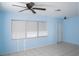 Bright living room with neutral tile floors, a ceiling fan, and ample natural light from multiple windows at 526 Hampton Ave, Lakeland, FL 33801