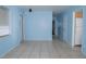 A large, bright living room with neutral tile floors, light blue walls, and multiple doors for easy access at 526 Hampton Ave, Lakeland, FL 33801