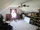 Spacious attic area with patterned carpeting, seating, ceiling fan and a window for natural lighting at 5626 Sawyer Rd, Lakeland, FL 33810