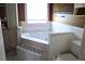 Relaxing soaking tub, surrounded by white tile accents, inside the main bath at 5626 Sawyer Rd, Lakeland, FL 33810