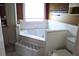 Bright bathroom featuring a soaking tub with white tile surround and decorative accents at 5626 Sawyer Rd, Lakeland, FL 33810
