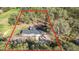 Aerial view of a home situated on a tree-filled lot, outlined in red to define the property lines at 5908 Lunn Rd, Lakeland, FL 33811