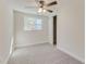 Bright bedroom with neutral carpet, ceiling fan, and natural light from the window at 5908 Lunn Rd, Lakeland, FL 33811