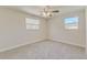 Bright bedroom featuring neutral carpet, dual windows, and a ceiling fan at 5908 Lunn Rd, Lakeland, FL 33811