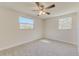 Bedroom featuring neutral carpeting, a ceiling fan, and two windows at 5908 Lunn Rd, Lakeland, FL 33811