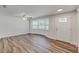 Bright living room features wood floors, a ceiling fan, and a large bay window at 5908 Lunn Rd, Lakeland, FL 33811