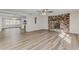 Bright living room featuring a brick fireplace, modern ceiling fan, and plank flooring at 5908 Lunn Rd, Lakeland, FL 33811