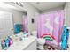 Cozy bathroom featuring a single sink vanity, toilet, and shower with playful unicorn-themed curtain at 5942 White Tail Loop, Lakeland, FL 33811