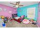 Colorful bedroom featuring pink and blue walls, a ceiling fan, and a collection of toys at 5942 White Tail Loop, Lakeland, FL 33811