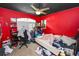 Bedroom with red walls, ceiling fan, large window, and cluttered personal belongings at 5942 White Tail Loop, Lakeland, FL 33811