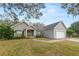 Home exterior featuring a front porch, well-kept lawn, and attached two-car garage at 5942 White Tail Loop, Lakeland, FL 33811