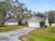 Exterior shot of a single-Gathering home with a driveway, a two-car garage, and well-maintained lawn at 5942 White Tail Loop, Lakeland, FL 33811