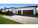 Exterior view of the home displaying its well-kept lawn, paved driveway, and spacious two-car garage at 6018 Abbey Oaks Dr, Lakeland, FL 33811