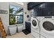 Laundry room with front-load washer and dryer, dark blue cabinets, and natural light at 6018 Abbey Oaks Dr, Lakeland, FL 33811