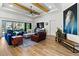 Living room with hardwood floors, exposed beam ceiling and view to screened in pool at 6018 Abbey Oaks Dr, Lakeland, FL 33811