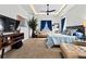 A view of the main bedroom showcasing tray ceilings, a ceiling fan, blue curtains, and neutral furniture at 6018 Abbey Oaks Dr, Lakeland, FL 33811