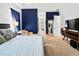 Bright main bedroom with a neutral palette, blue accent wall, and a glimpse into the en-suite bathroom at 6018 Abbey Oaks Dr, Lakeland, FL 33811