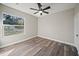 A cozy bedroom featuring a large window and sleek hardwood flooring at 602 E Orange St, Auburndale, FL 33823