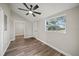 This bedroom has wood flooring, a ceiling fan, a window, and an adjacent laundry area at 602 E Orange St, Auburndale, FL 33823